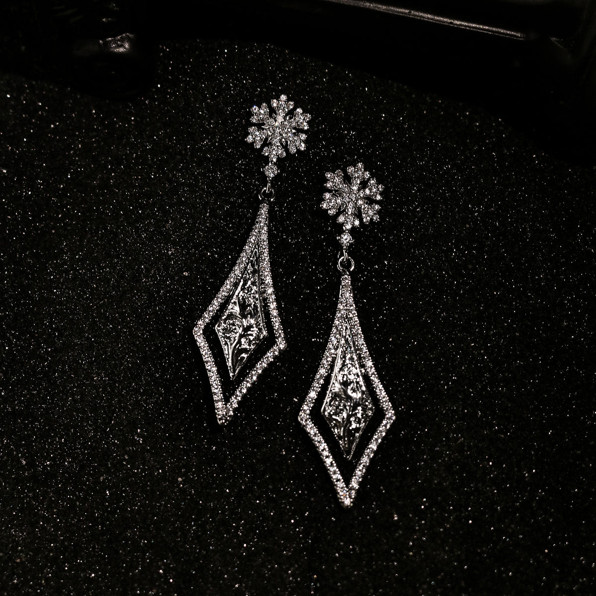 Top view of Rock & Republic Cubic Zirconia Snowflake Filigree Drop Earrings in Silver with pave border and inner filigree.