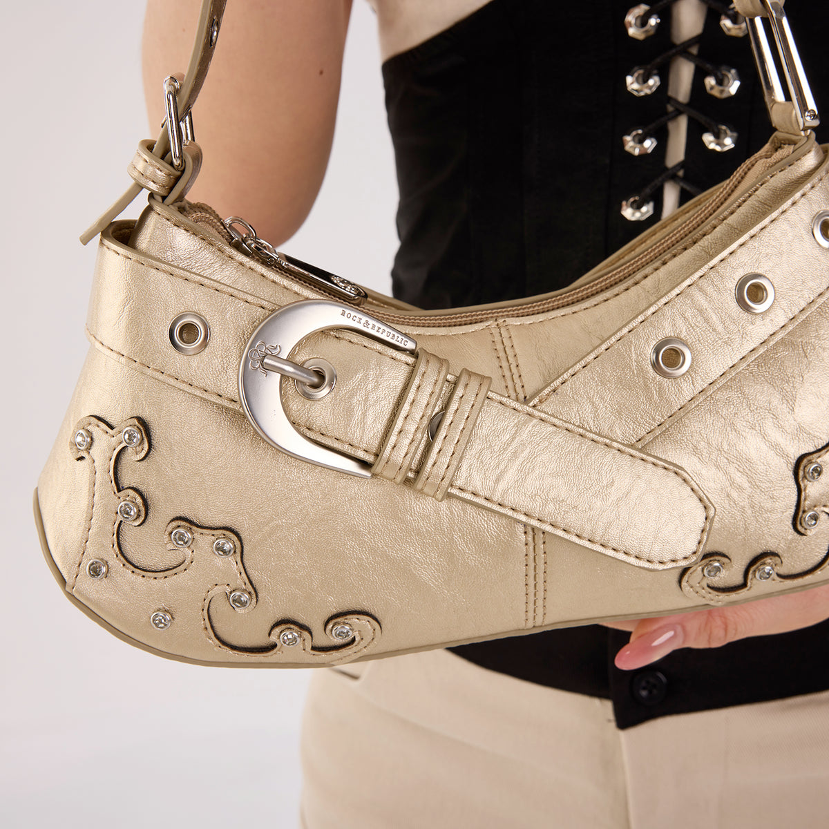 Rock & Republic Crystal Wave Baguette Shoulder Bag in Gold PU close-up showing engraved buckle and baguette profile.