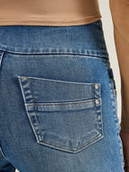 Macro view of Rock & Republic Women's Fever Legging in Last Call showing rear patch pocket with metallic rivet details.