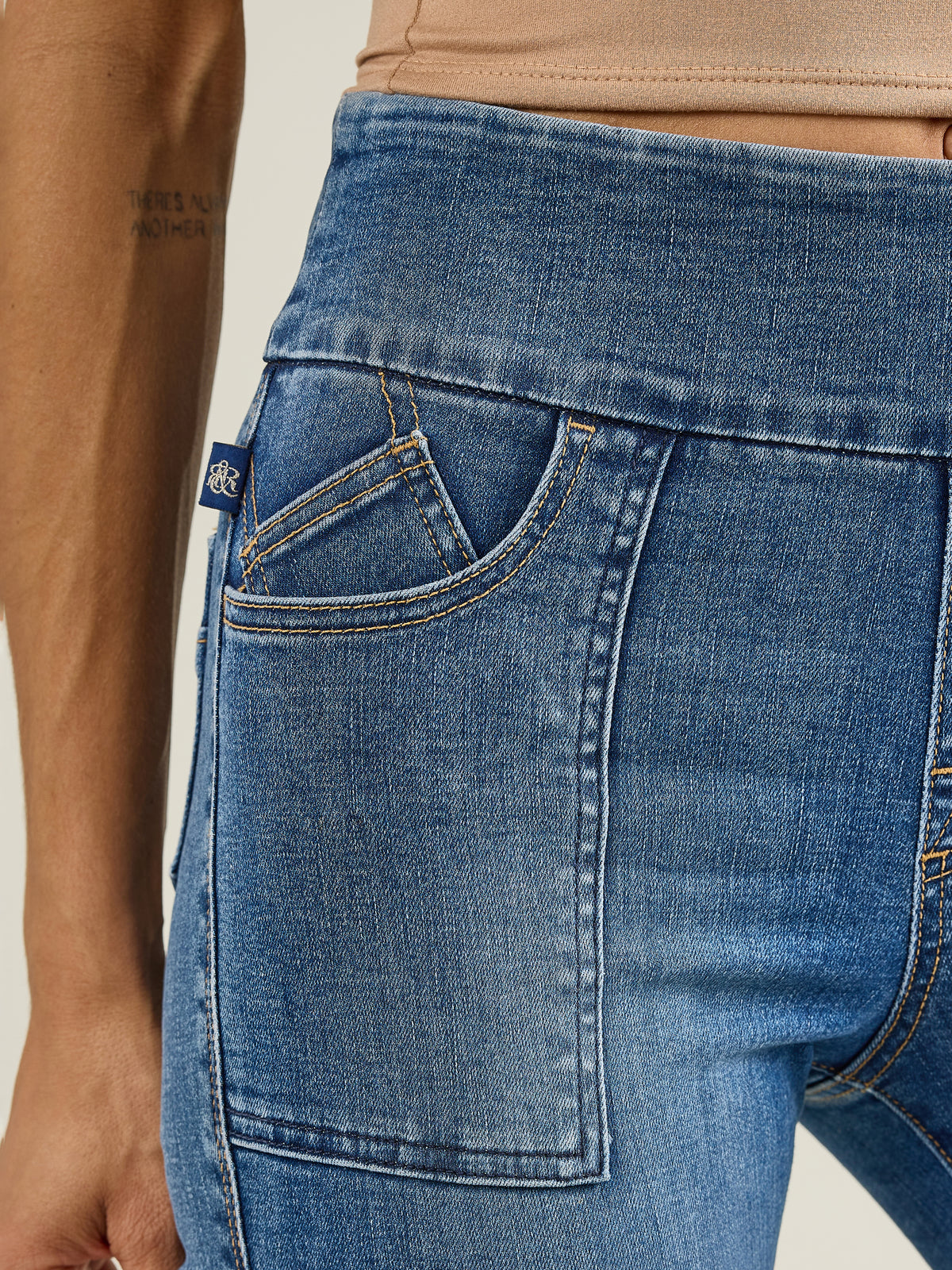 Front detail of Rock & Republic Women's Fever Legging in Last Call showing elastic pull-on waistband and blue RR logo tab.