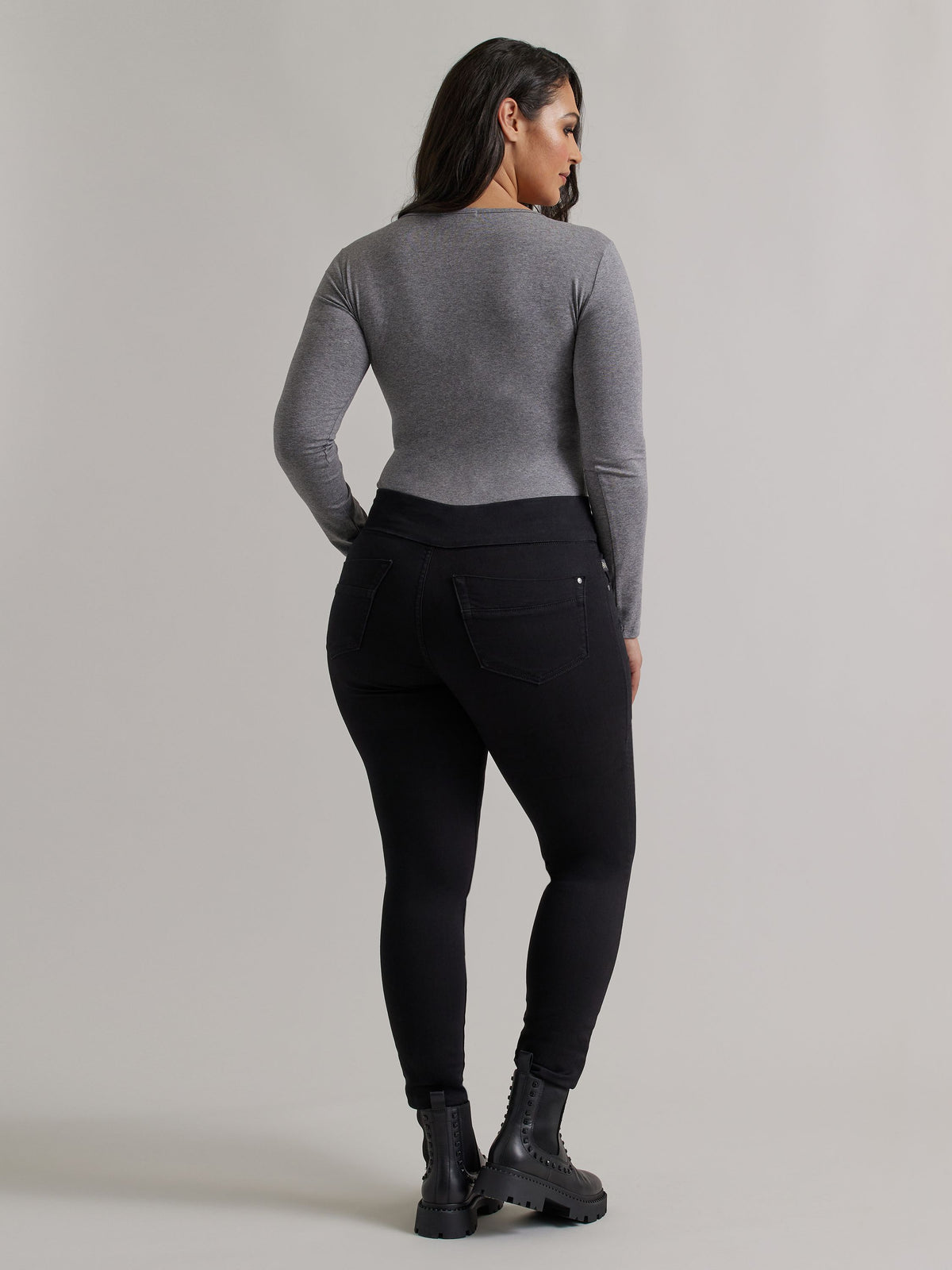 Back view of Rock & Republic Women's Fever Legging in DNA wash on curve model showing sculpting rear pockets and sleek fit.