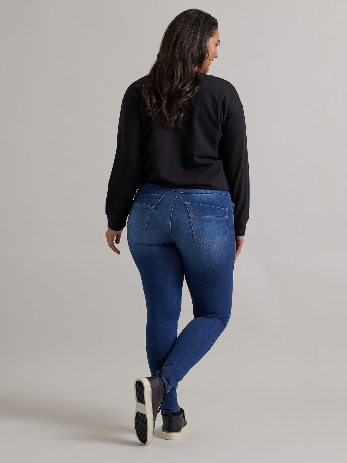 Back view of Rock & Republic Women's Fever Legging in Come Thru on curve model showing sculpting rear patch pockets.