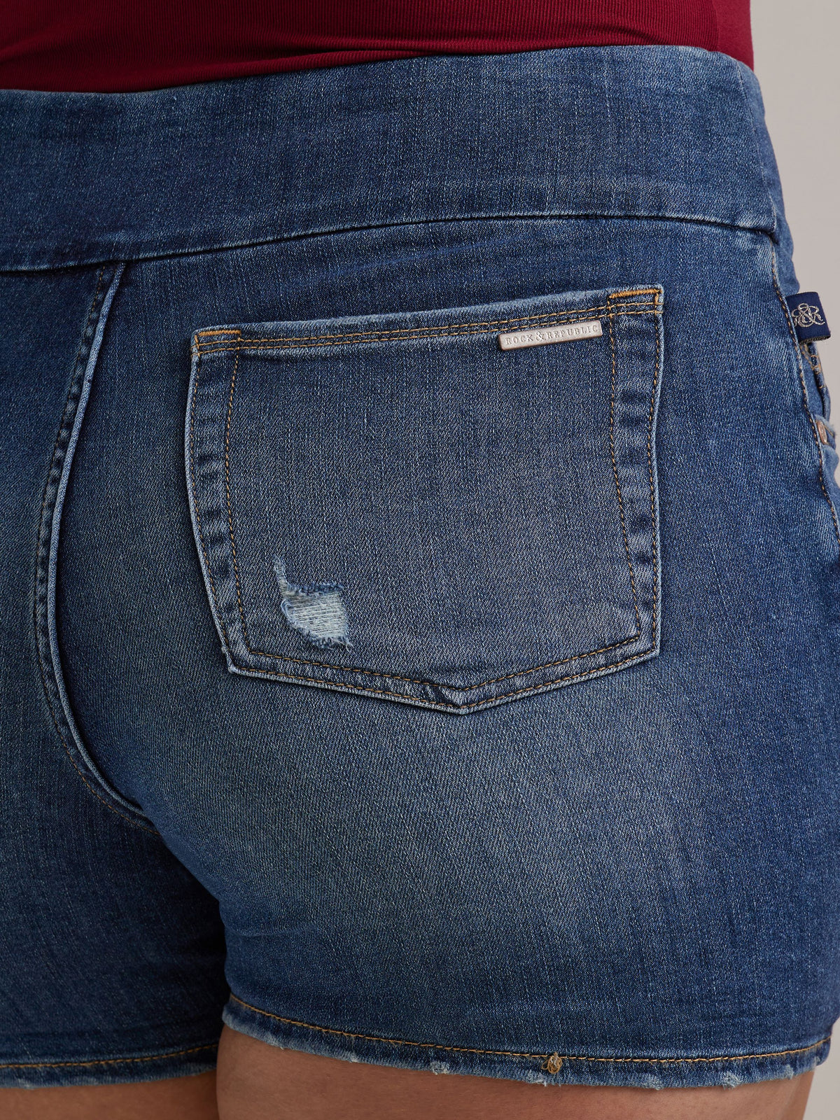 Macro view of Rock & Republic Fever Pull-On Short in Symptomatic showing rear patch pocket with metal logo bar and nick.