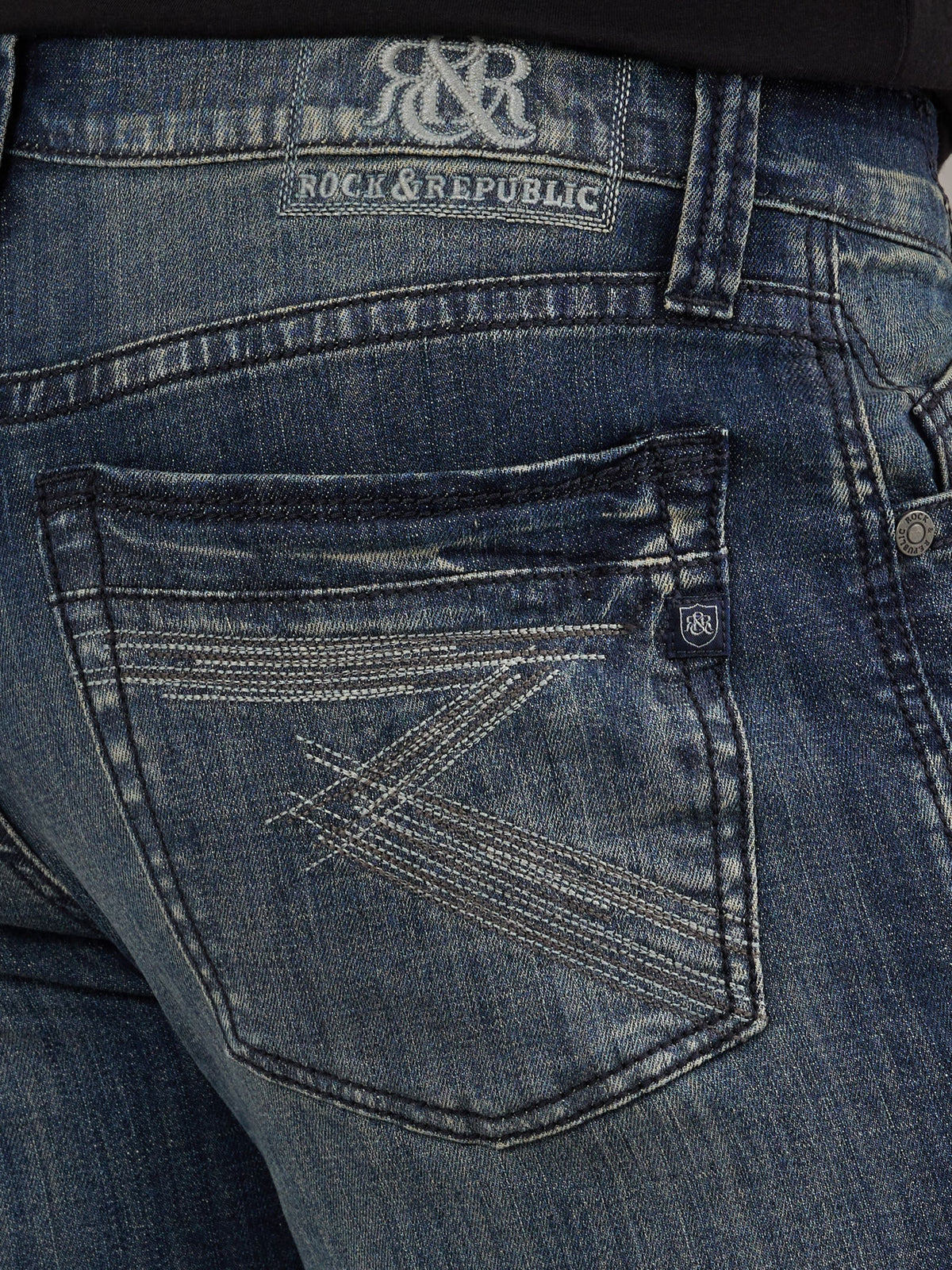 Detailed back pocket view of Rock & Republic Neil jeans in Street Cred showing geometric multi-stitch design & crest tab.