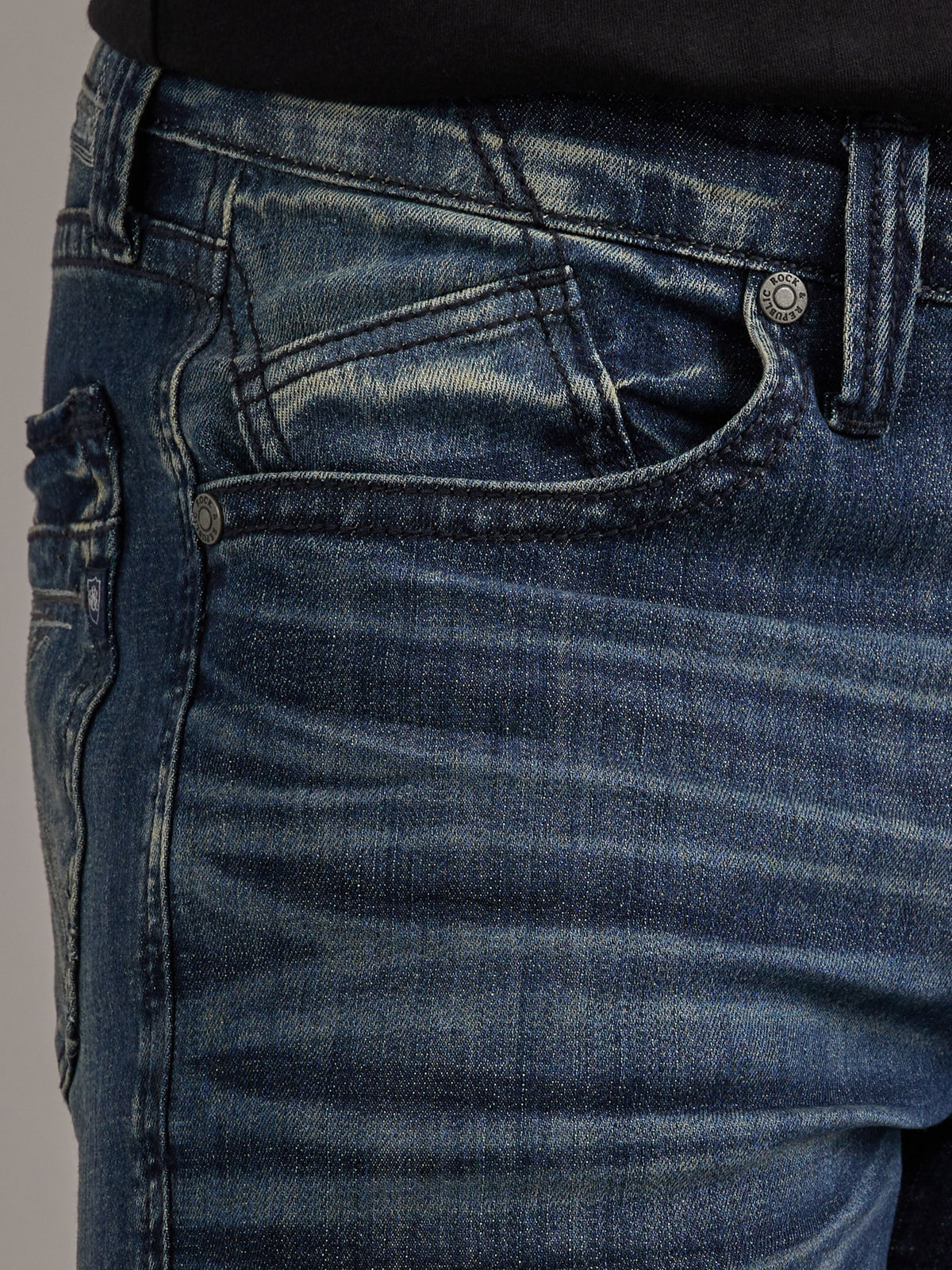 Close-up of Rock & Republic Neil jeans front waist in Street Cred showing angled inset coin pocket and hip whiskering.