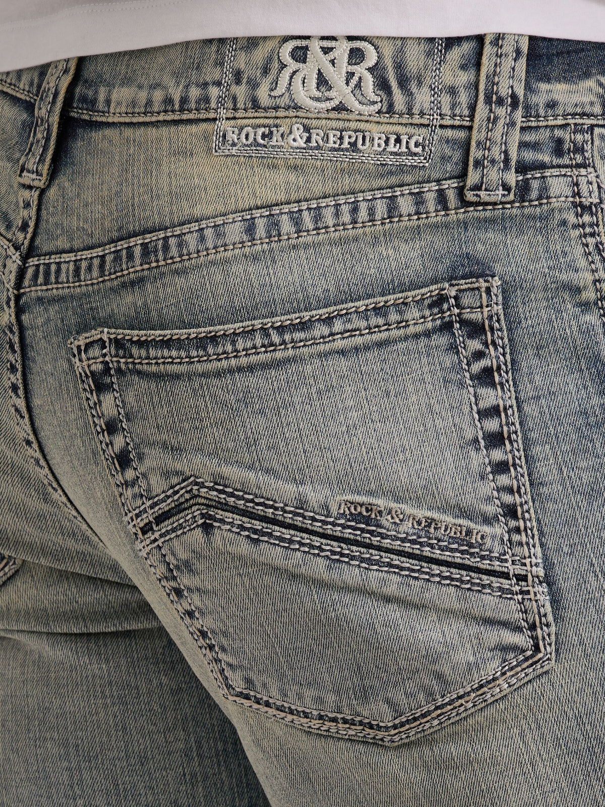 Detailed back pocket view of Rock & Republic Neil jeans in Haze showing embroidered denim waist patch and rear stitching.