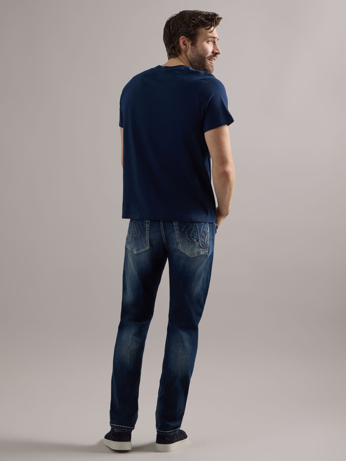 Back full view of Rock & Republic Colburg slim straight jeans in Mad Skills highlighting oversized embroidered R pockets.