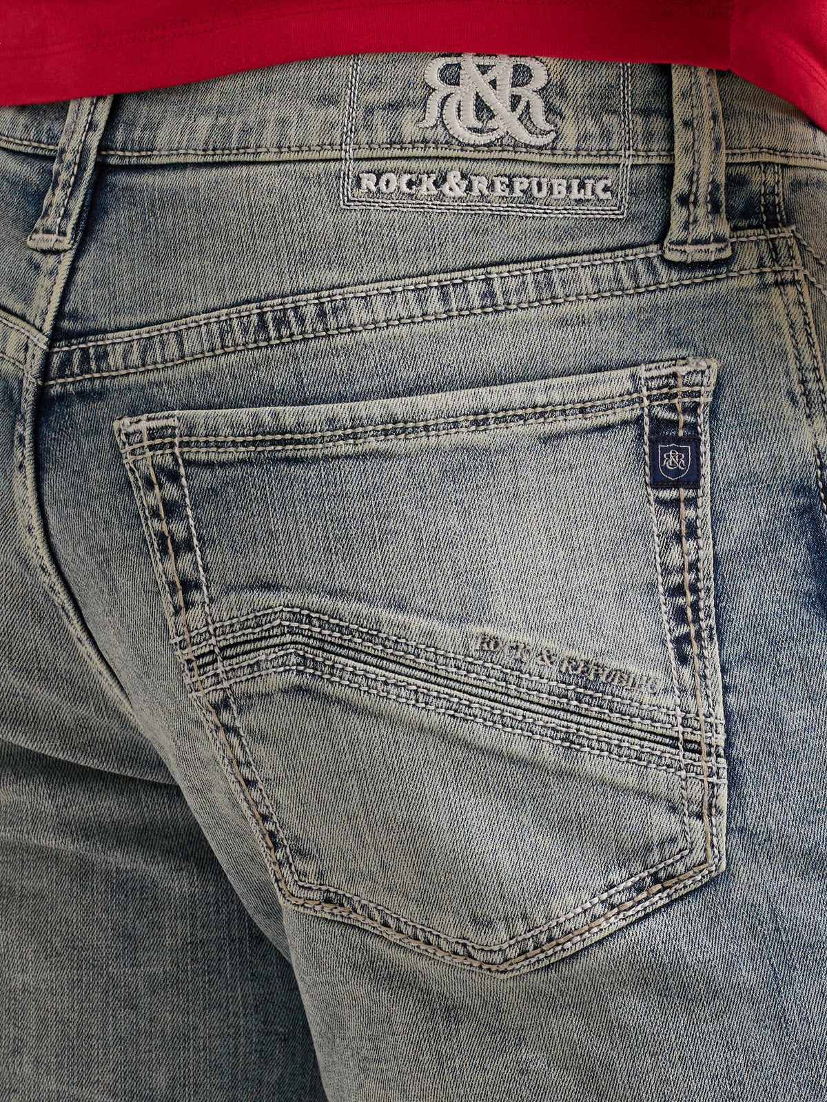 Detailed back pocket view of Rock & Republic Grady jeans in Haze showing embroidered denim waist patch and crest tab.