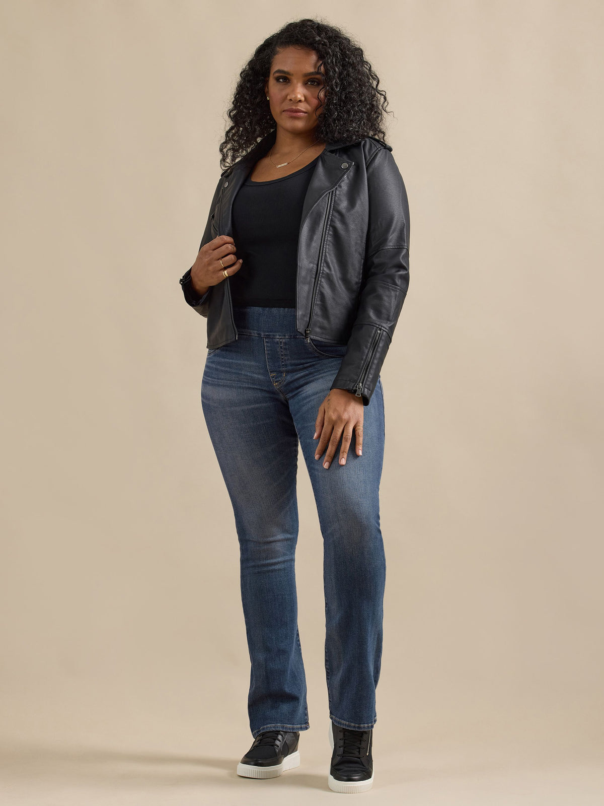Front view of Rock & Republic Fever pull-on bootcut jeans in Glamazon on curve model styled with black moto leather jacket.