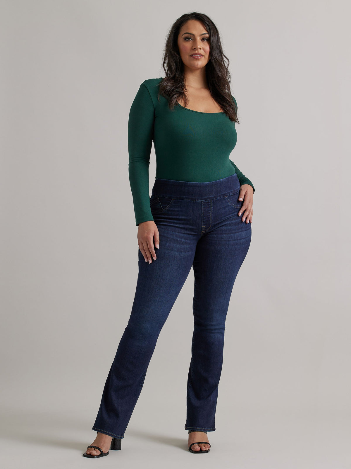 Front view of Rock & Republic Fever pull-on bootcut jeans in Heart Beat on curve model showing polished dark rinse denim.