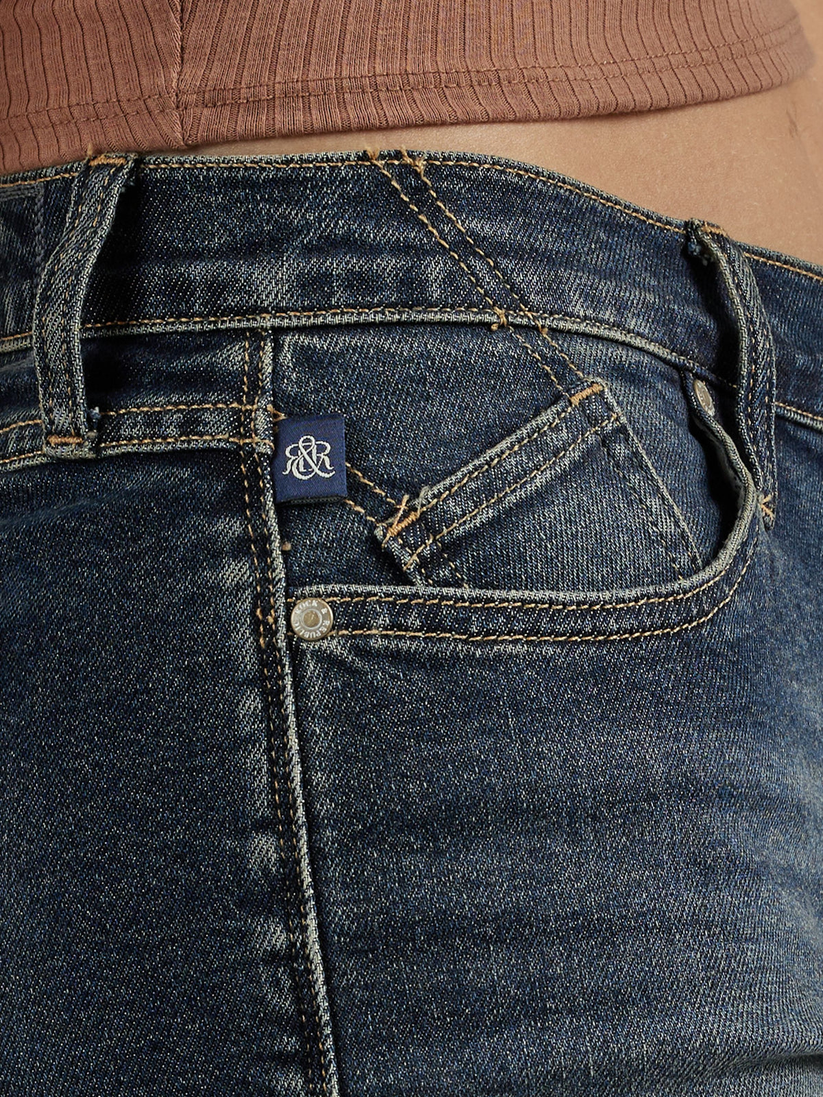 Front pocket detail of Rock & Republic Hula Short in It Girl showing coin pocket, metal rivet, and blue woven RR tab.