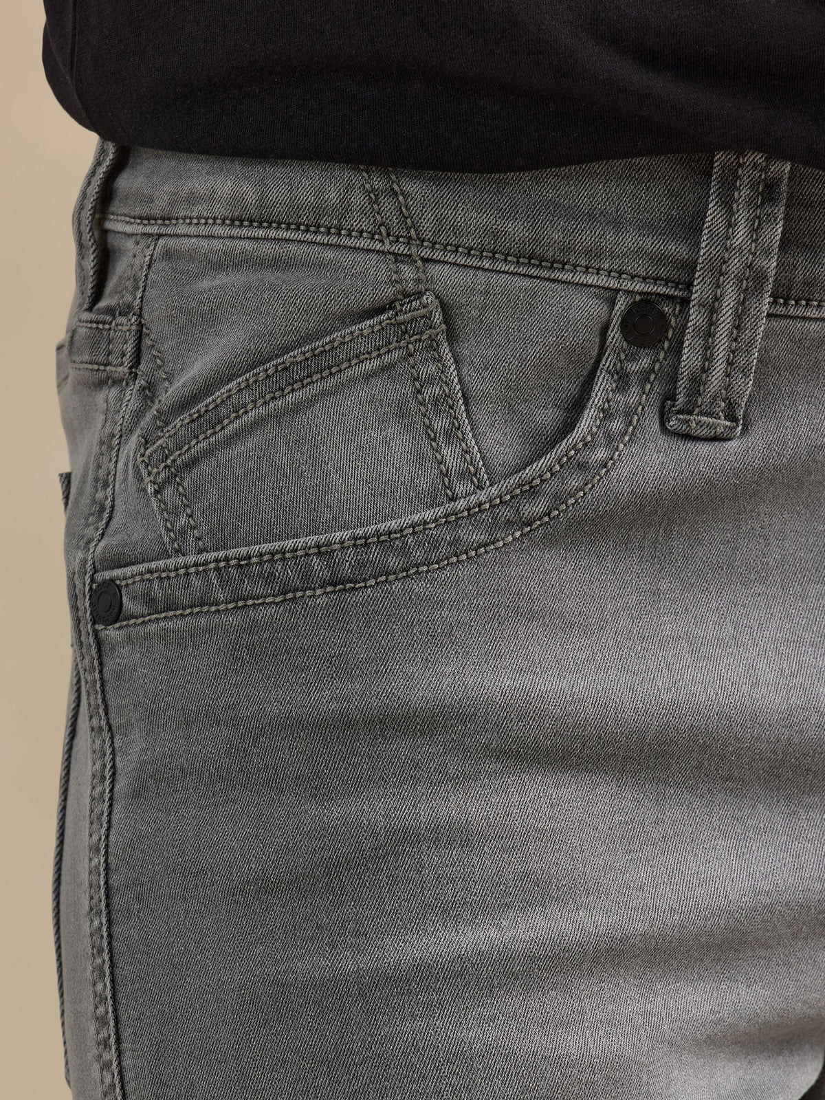 Close-up of Rock & Republic Neil jeans front waist in Toner Low showing angled coin pocket and tonal rivet detailing.