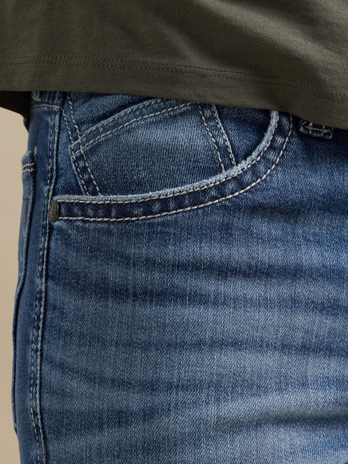 Close-up of Rock & Republic Neil jeans front waist in Best Bet showing angled inset coin pocket and branded rivet details.
