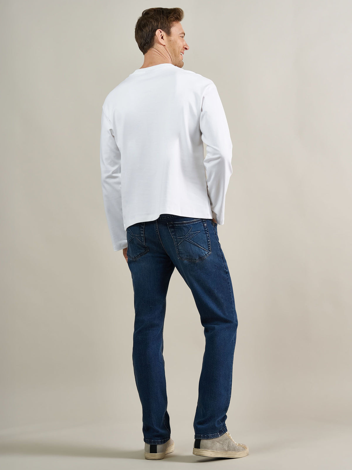 Back full view of Rock & Republic Neil straight jeans in Boys Club showing star-stitched pockets and straight leg fit.