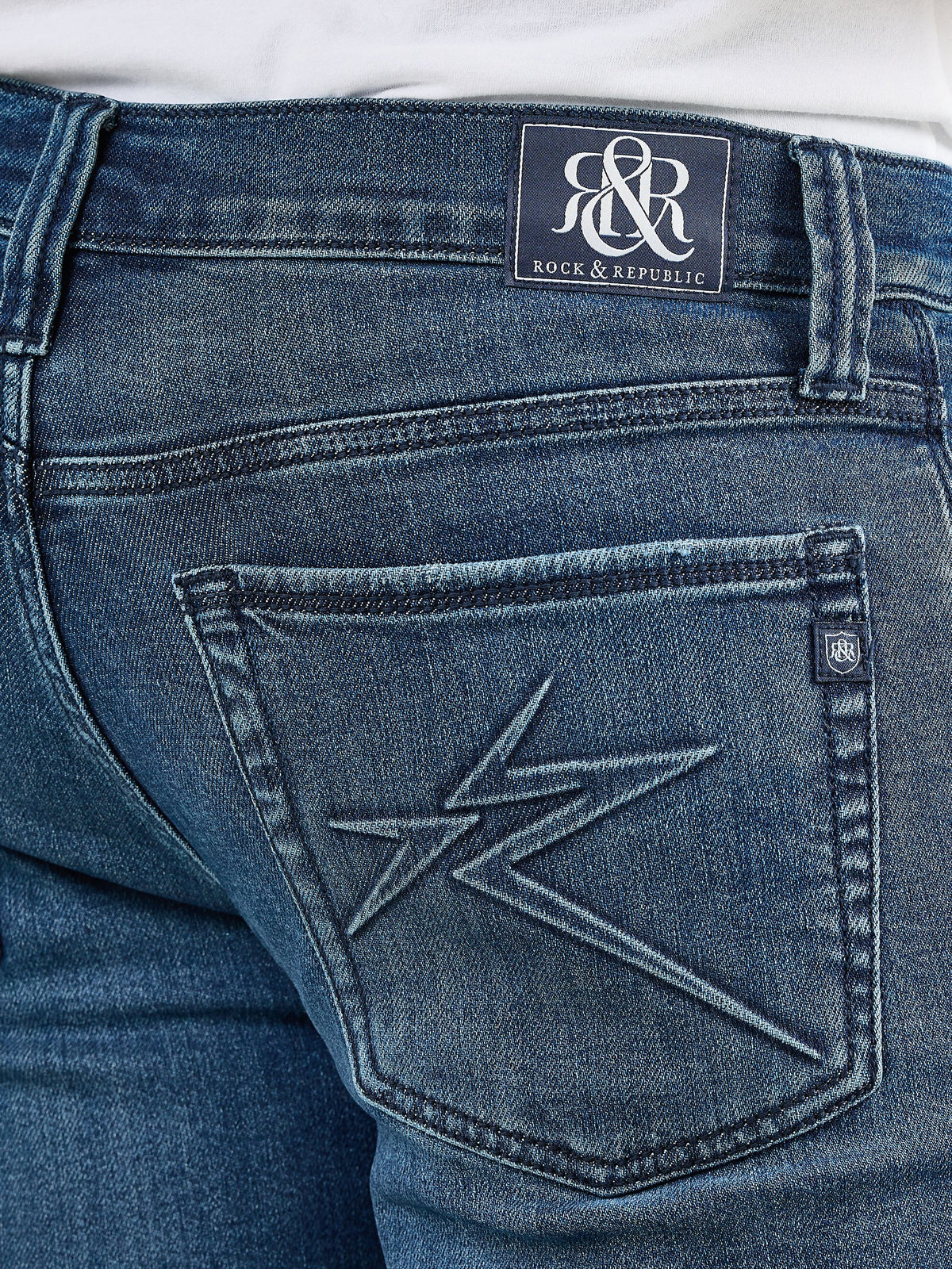 Detailed back pocket view of Rock & Republic Neil jeans in Boys Club showing star embroidery and denim R&R logo patch.