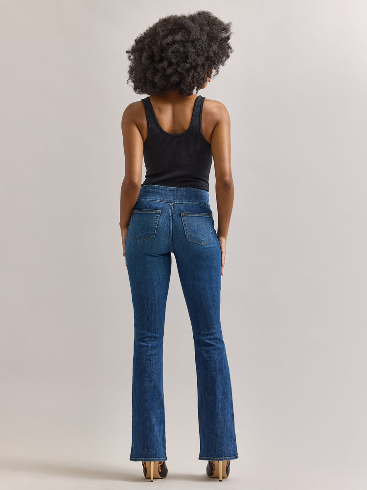 Back full view of Rock & Republic Fever pull-on bootcut jeans in Heartfelt showing clean rear pockets and flare hemline.