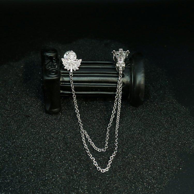Display view of Rock & Republic Chain-Embellished Brooch in Antique Silver showing crowned skull and pave maple leaf pin.