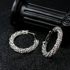 Top view of Rock & Republic Cubic Zirconia Orbit Circle Earrings in Silver with twisted pave hoops and latch-back clasp.