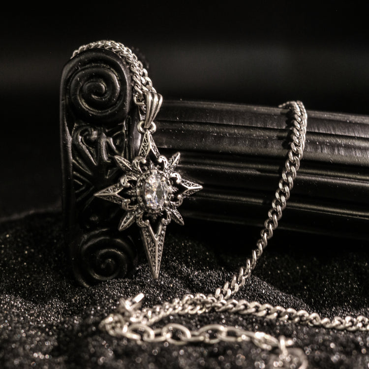 Macro view of Rock & Republic rhinestone embellished starburst pendant necklace in Antique Silver with ornate star charm