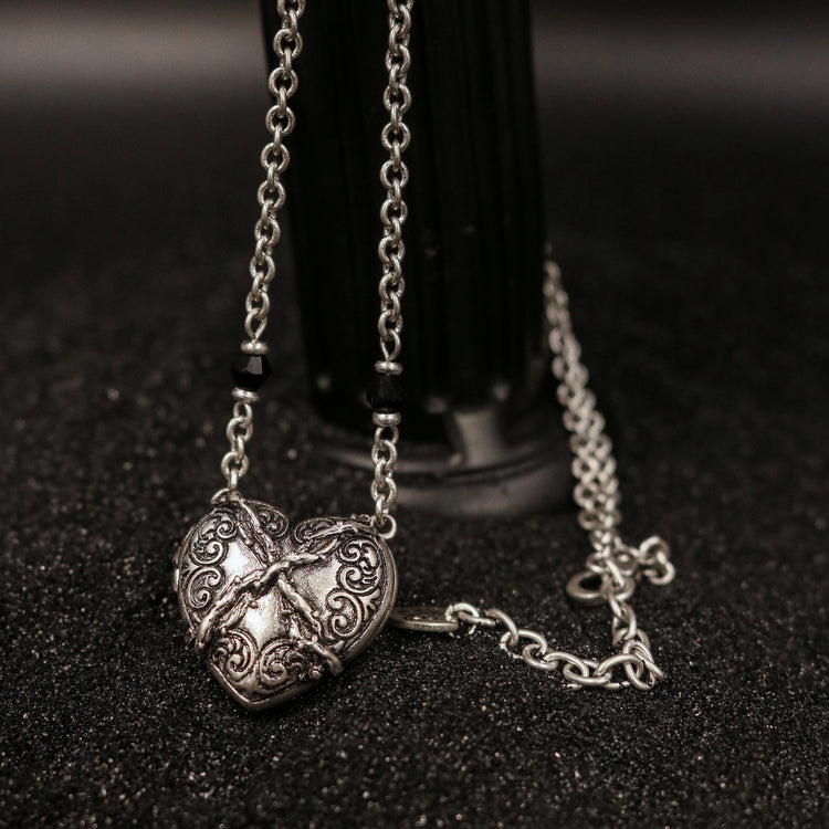 Rock & Republic ornate winged heart chain necklace in Antique Silver showing engraved heart locket and black bead accents.