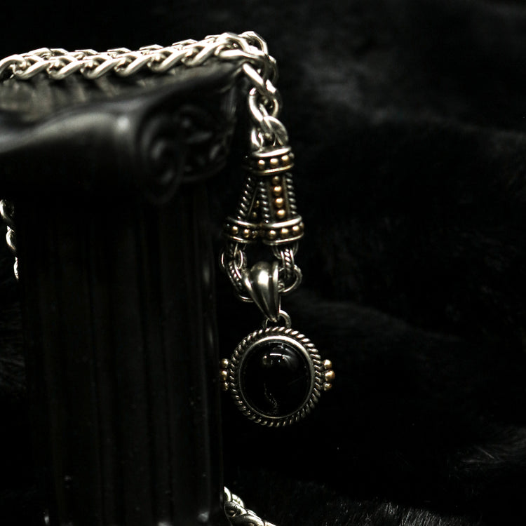 Vertical macro view of Rock & Republic black cabochon link chain necklace in Antique Silver draped on black prop column.