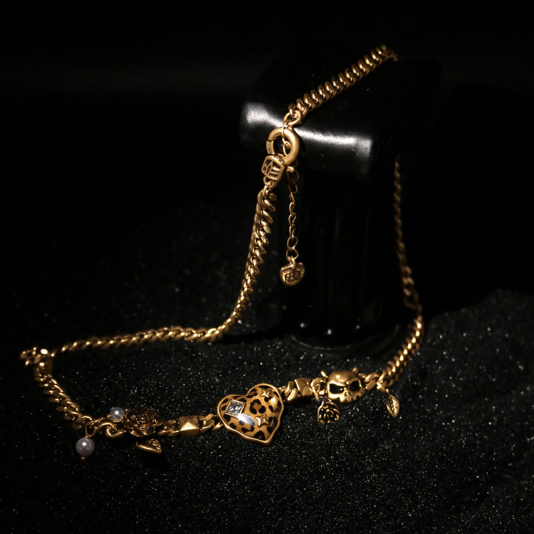 Rock & Republic leopard heart skull charm chain necklace in Gold showing leopard print heart, skull, and pearl charms.