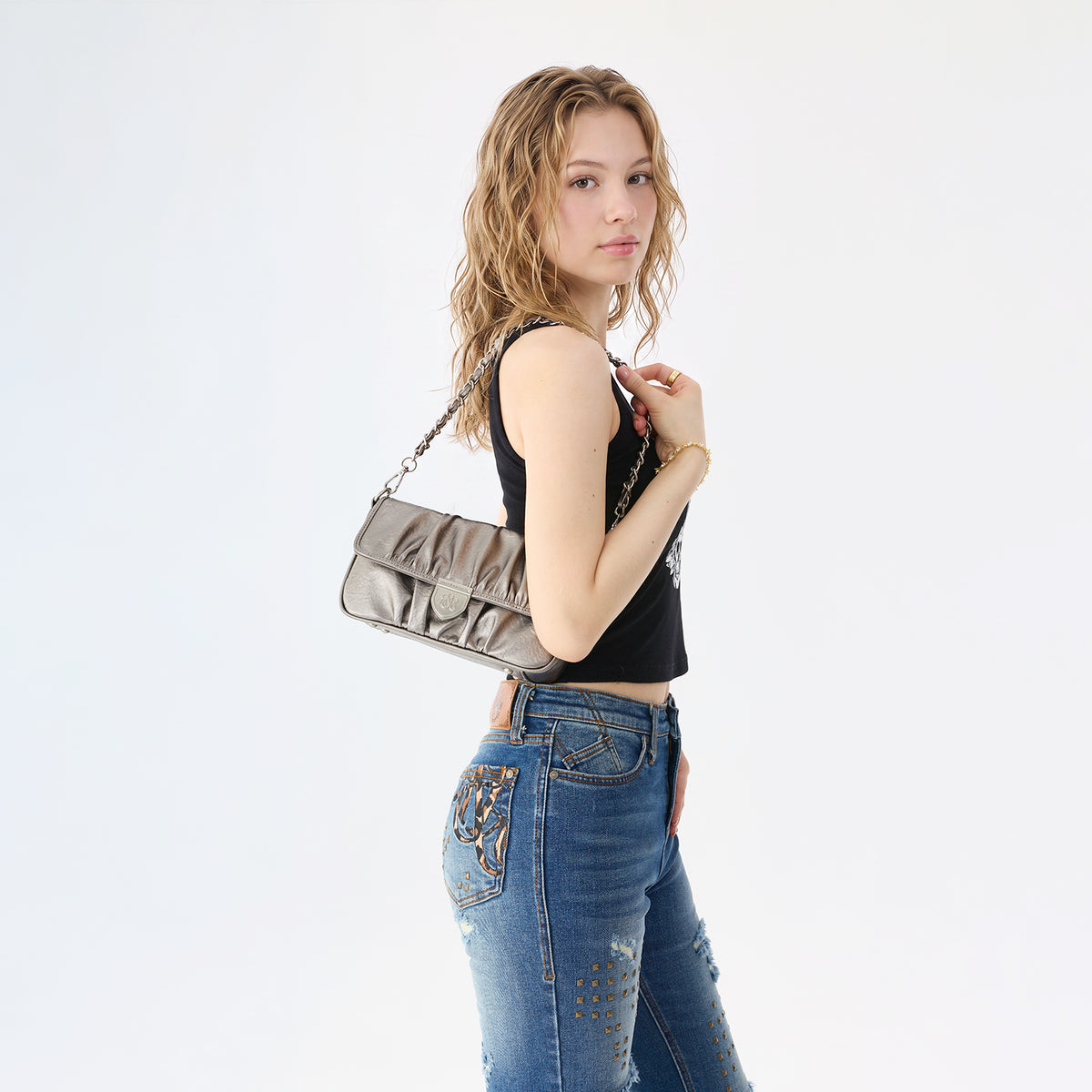 Rock & Republic Shield Logo Ruched Crossbody Bag in Taupe PU worn on shoulder showing crossbody silhouette.